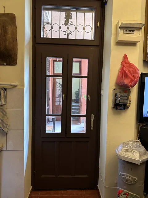 Külvárosi, egy szárnyas bejárati ajtó az eredetivel megegyező nézetben, hőszigetelt üveggel, nyitható ablakokal hatpontos biztonsági zárral, barna zománc fényezéssel.